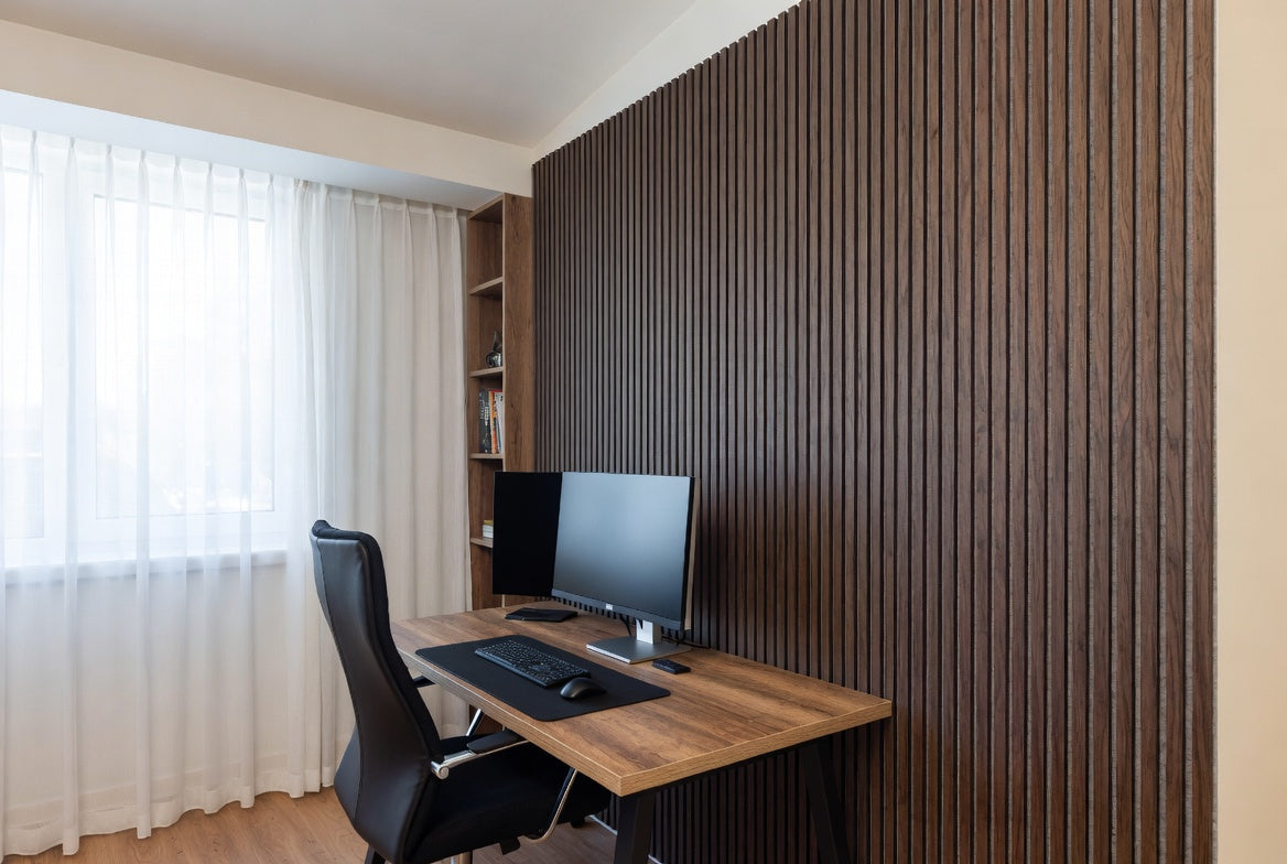 Calm home office with wood slat acoustic wall behind desk.
